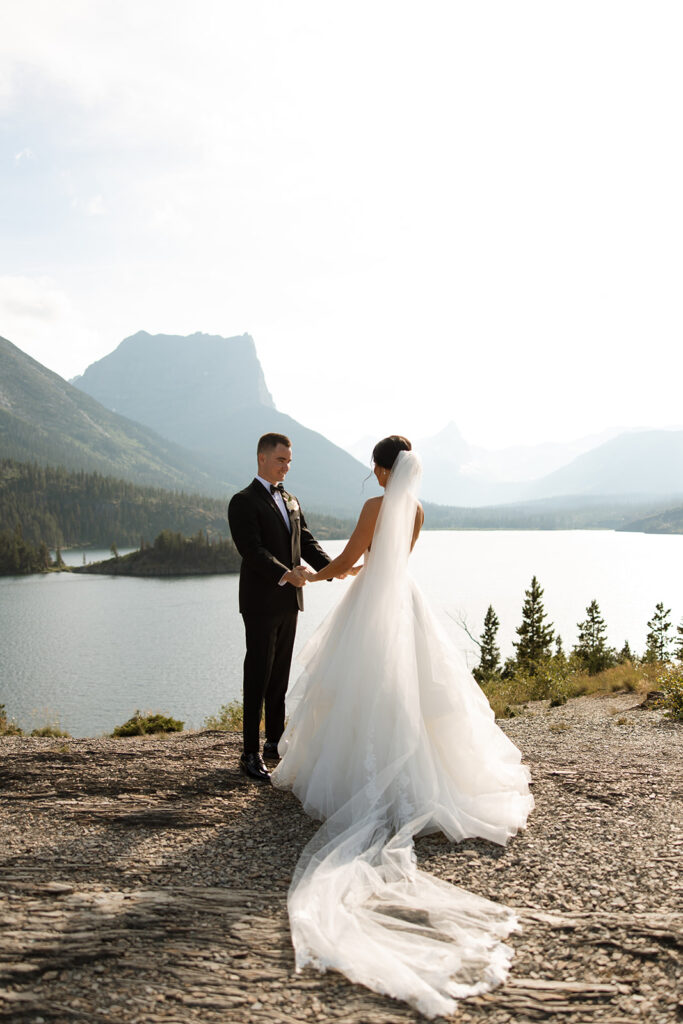 Bride and groom holding hands during their Sun Point ceremony in Glacier National Park
