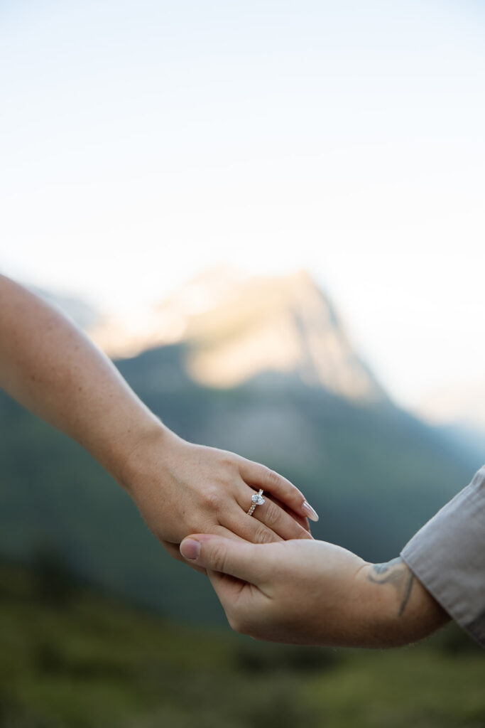 Romantic moment of a couple holding hands while walking along the trails in Glacier National Park.
