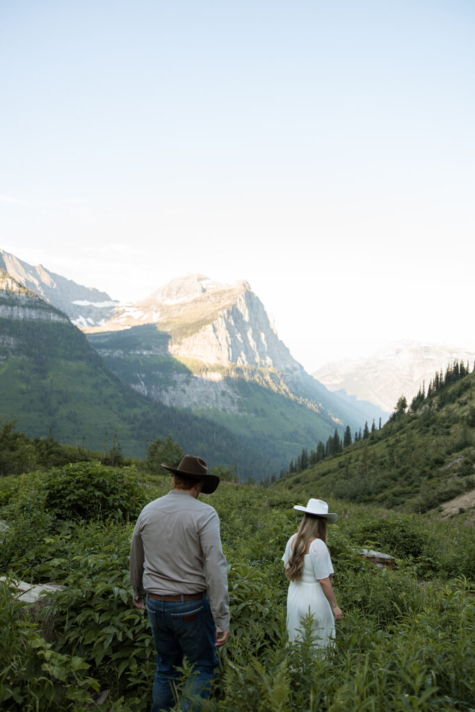 Romantic moment of a couple holding hands while walking along the trails in Glacier National Park.
