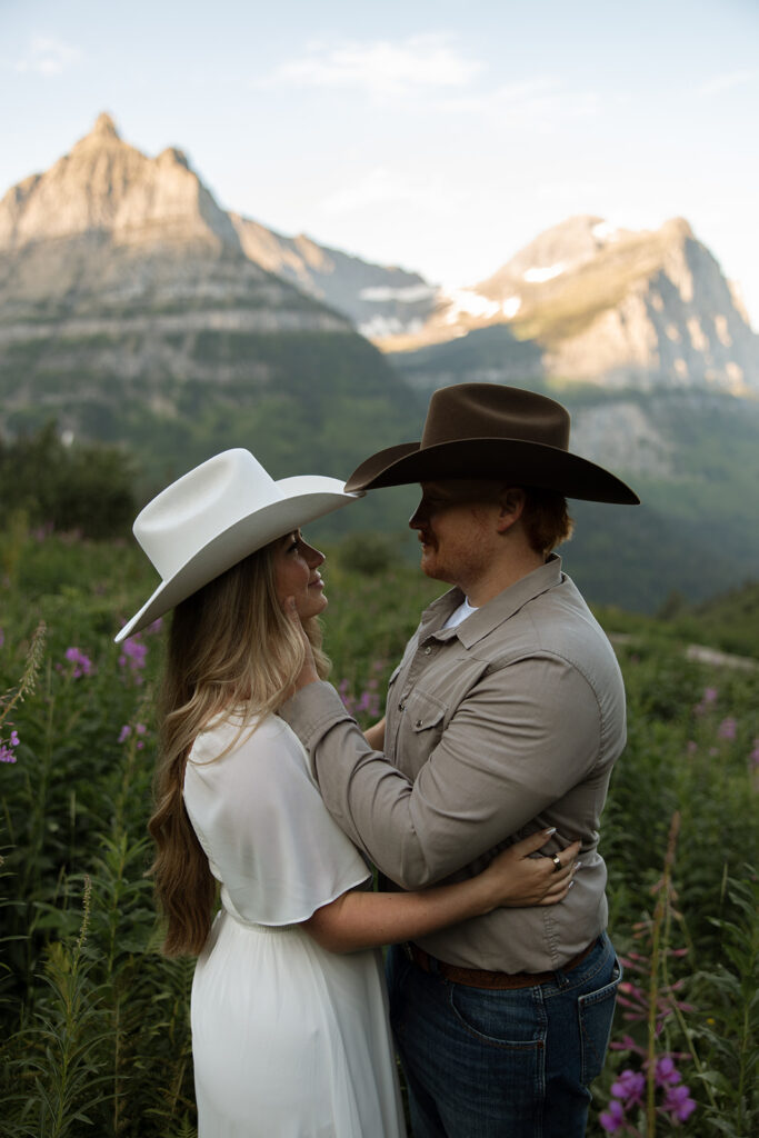 Candid photo of an engaged couple sharing a laugh against the backdrop of Glacier’s peaks.
