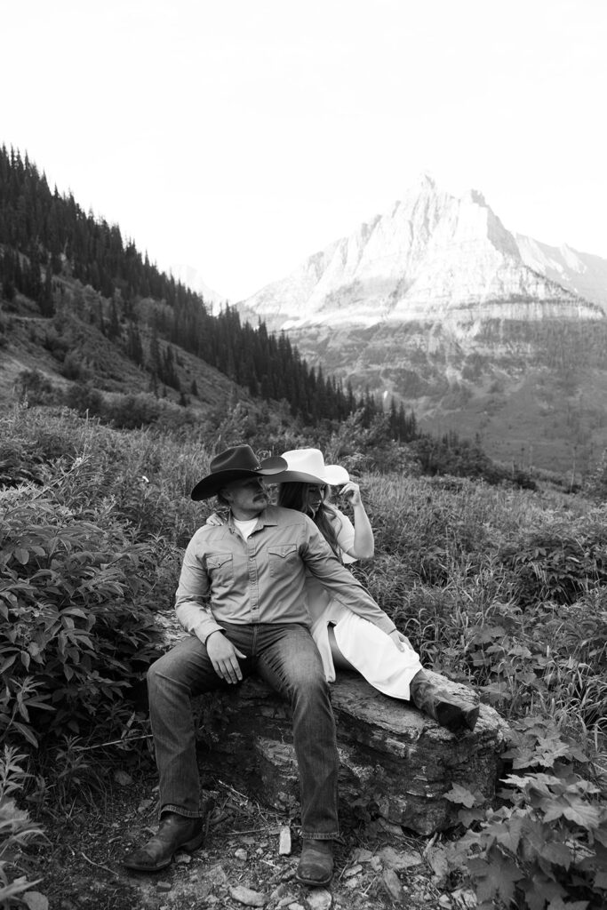 Couple laughing together during a sunrise fun engagement shoot along the Going-to-the-Sun Road in Glacier National Park.
