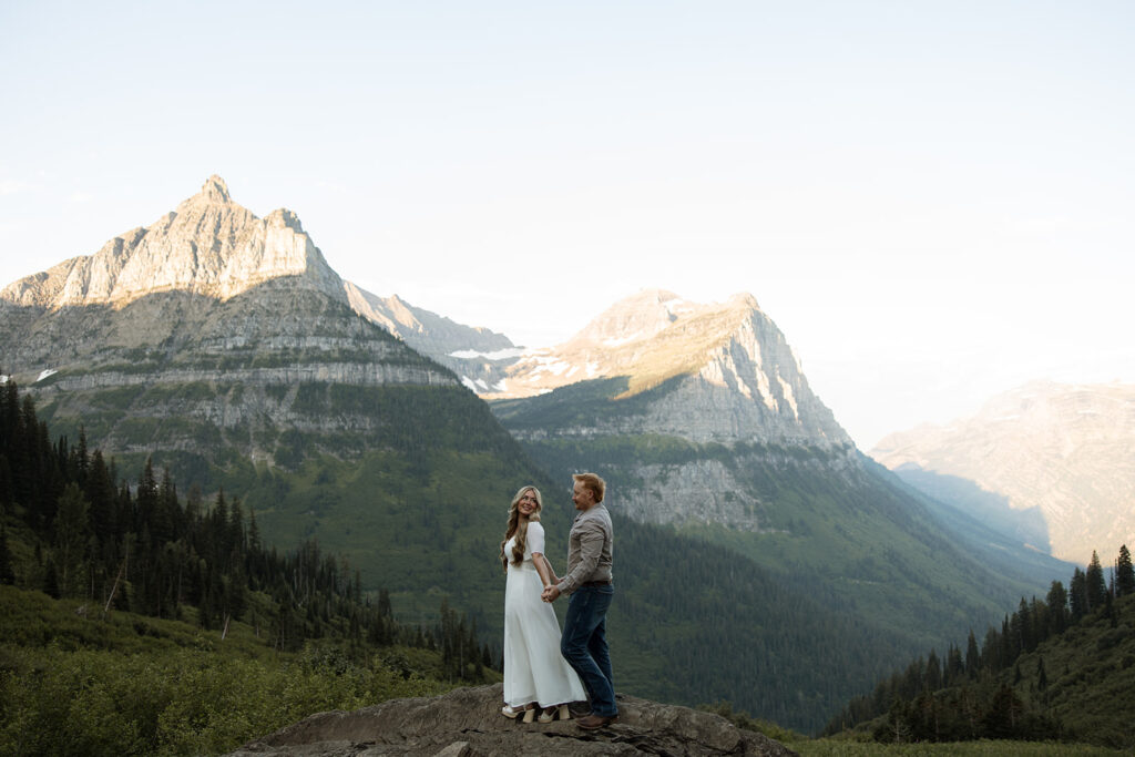 Romantic moment of a couple holding hands while walking along the trails in Glacier National Park.
