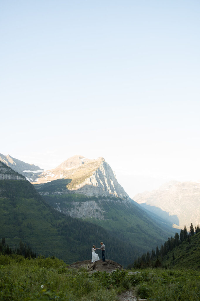 Romantic moment of a couple holding hands while walking along the trails in Glacier National Park.

