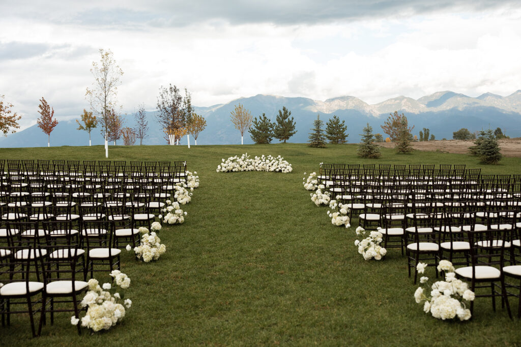 Wedding ceremony overlooking open fields and distant peaks in Montana.
