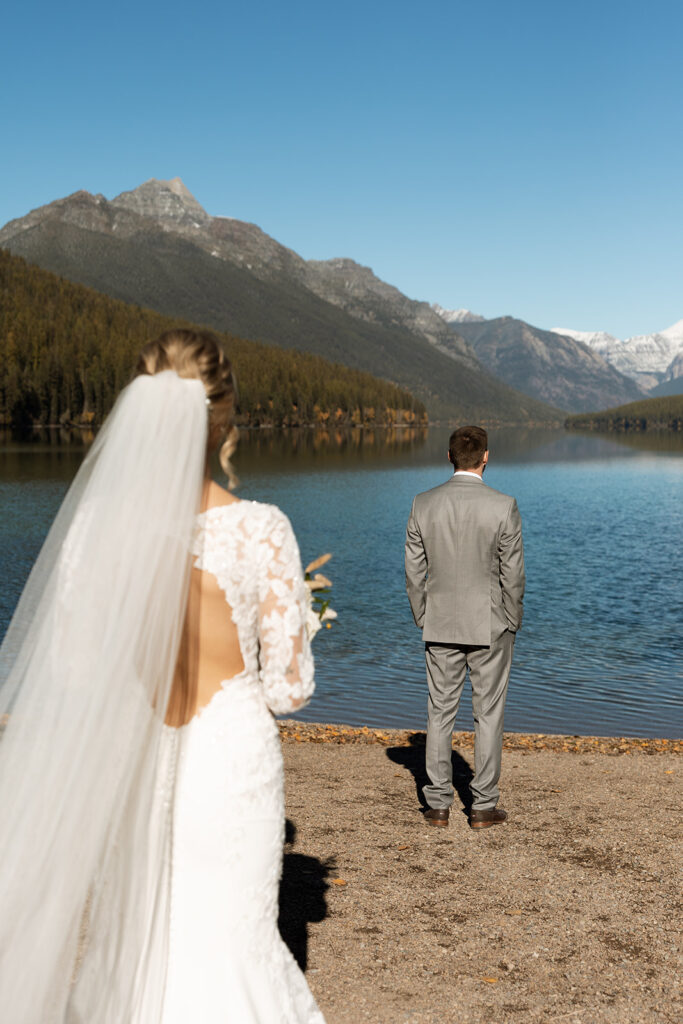 Couple standing on the shore of Bowman Lake in Montana during their Glacier National Park elopement
