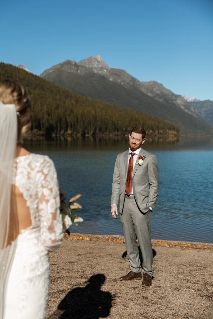 Couple standing on the shore of Bowman Lake in Montana during their Glacier National Park elopement

