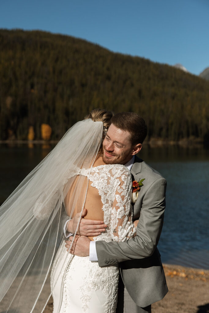 Couple standing on the shore of Bowman Lake in Montana during their Glacier National Park elopement
