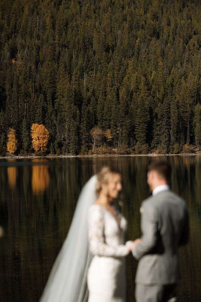 Bride and groom sharing a quiet moment beside the turquoise water at Bowman Lake
