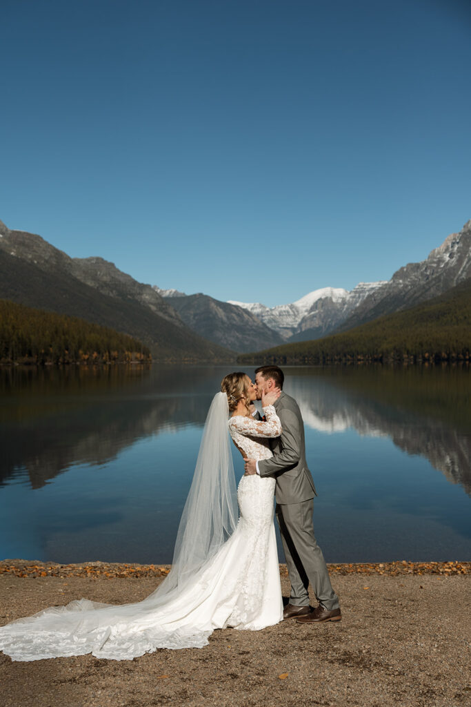 Bride and groom sharing a quiet moment beside the turquoise water at Bowman Lake