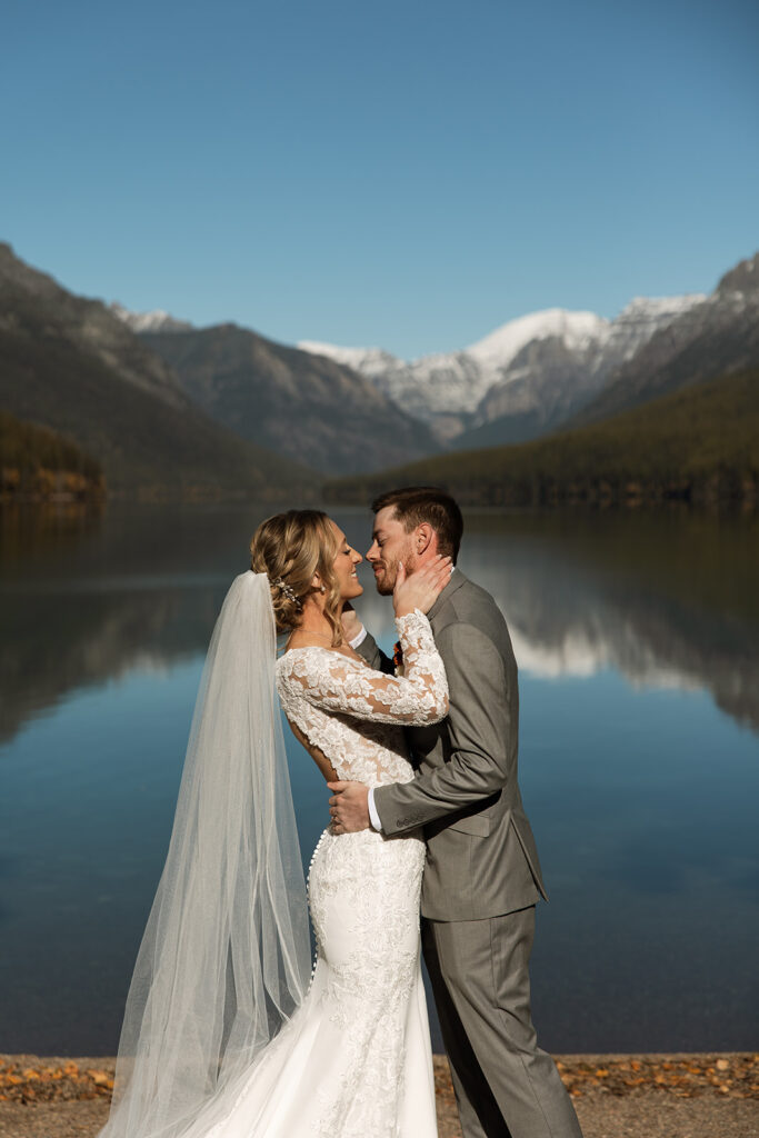 Bride and groom sharing a quiet moment beside the turquoise water at Bowman Lake
