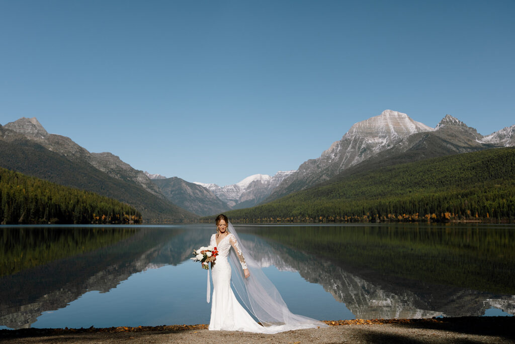 Bride and groom sharing a quiet moment beside the turquoise water at Bowman Lake
