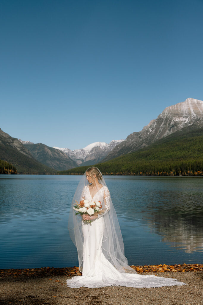 Bride and groom sharing a quiet moment beside the turquoise water at Bowman Lake
