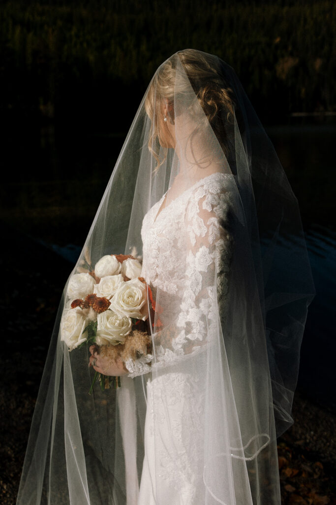 Newlyweds walking along the forest path near Bowman Lake after their ceremony
