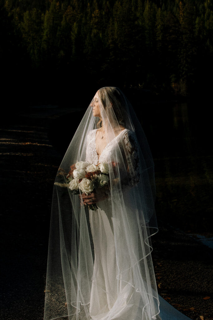 Newlyweds walking along the forest path near Bowman Lake after their ceremony
