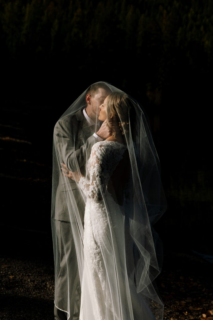 Newlyweds walking along the forest path near Bowman Lake after their ceremony