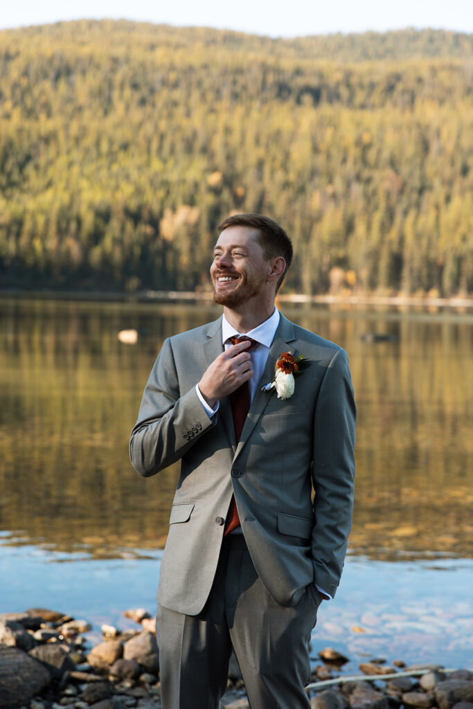 Bride and groom sharing a quiet moment beside the turquoise water at Bowman Lake
