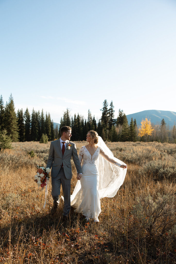 Newlyweds walking along the forest path near Bowman Lake after their ceremony
