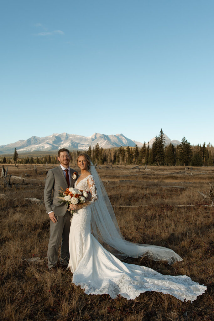 Newlyweds walking along the forest path near Bowman Lake after their ceremony
