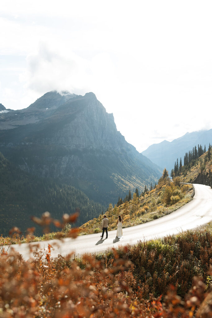 Romantic elopement portraits in Glacier National Park with dramatic clouds and layered mountain scenery