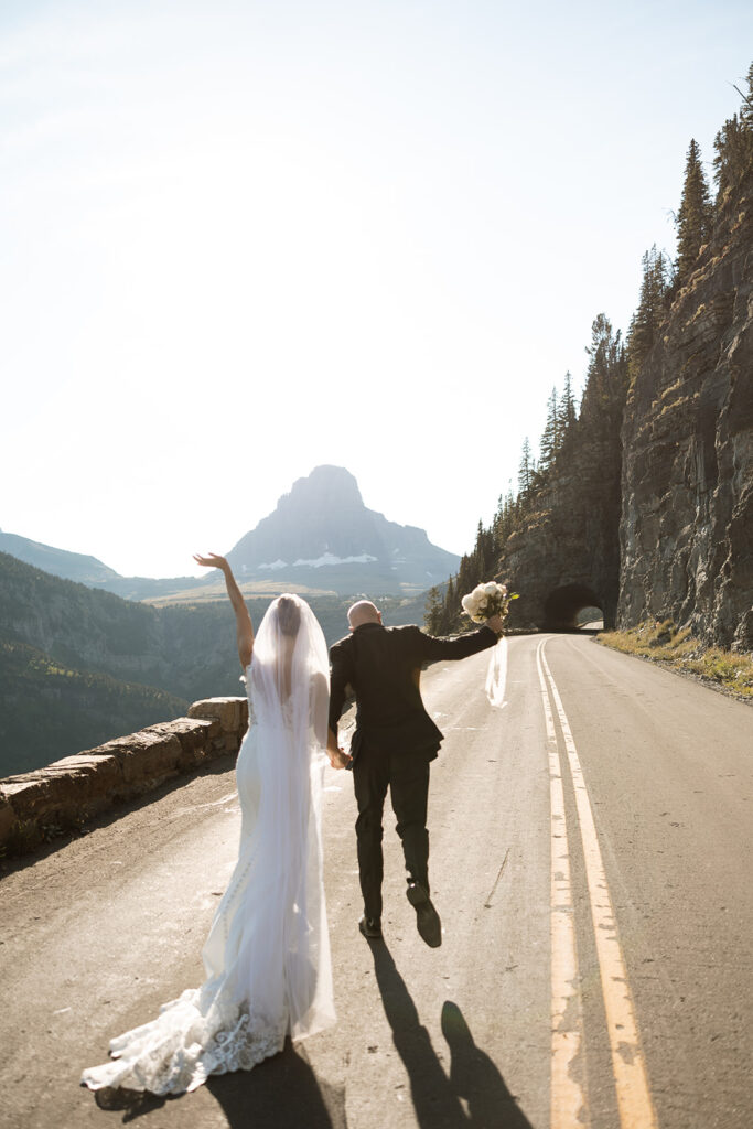Elopement couple laughing together in Glacier National Park after their vows
