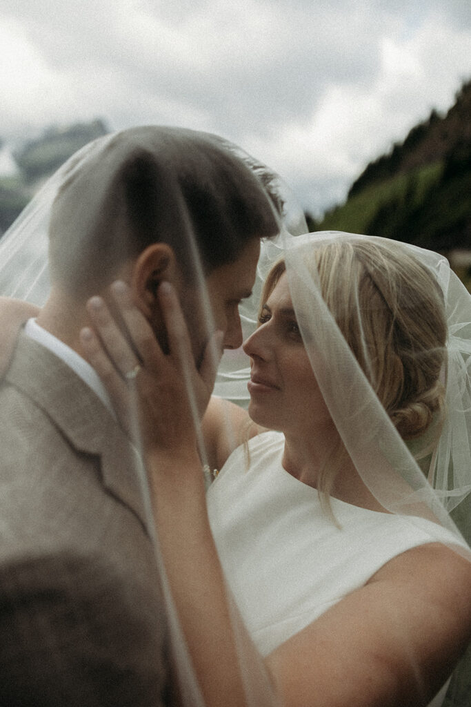 Bride and groom hiking through alpine scenery on their elopement day.