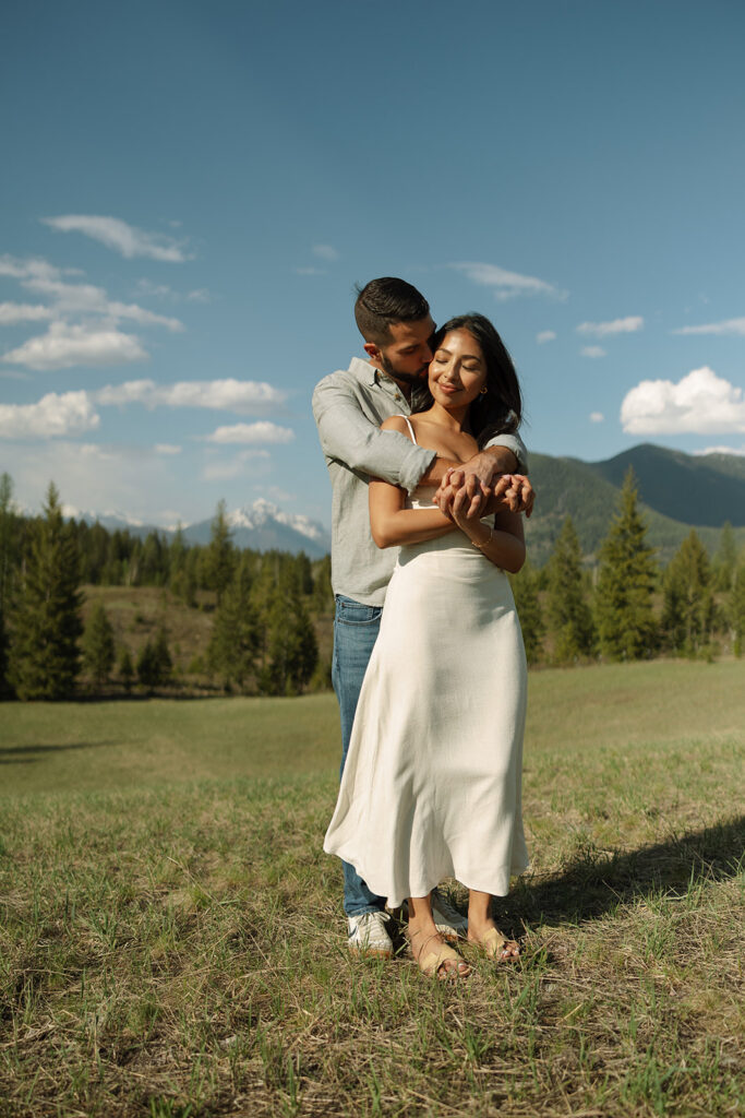 Couple holding hands in a wide open landscape during their Glacier National Park engagement session
