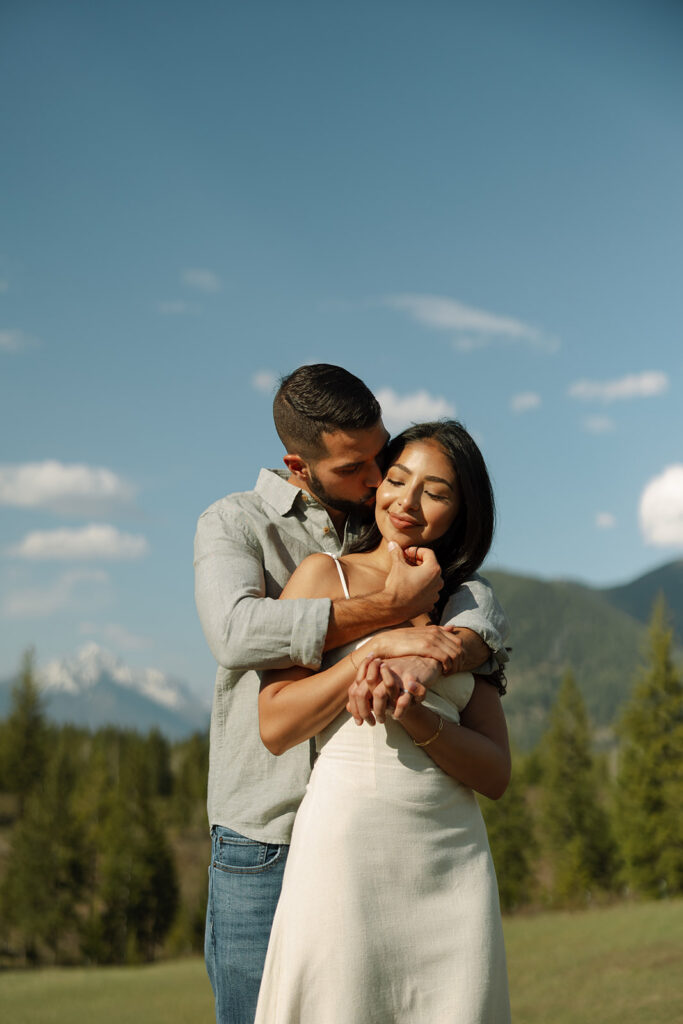 Couple holding hands in a wide open landscape during their Glacier National Park engagement session
