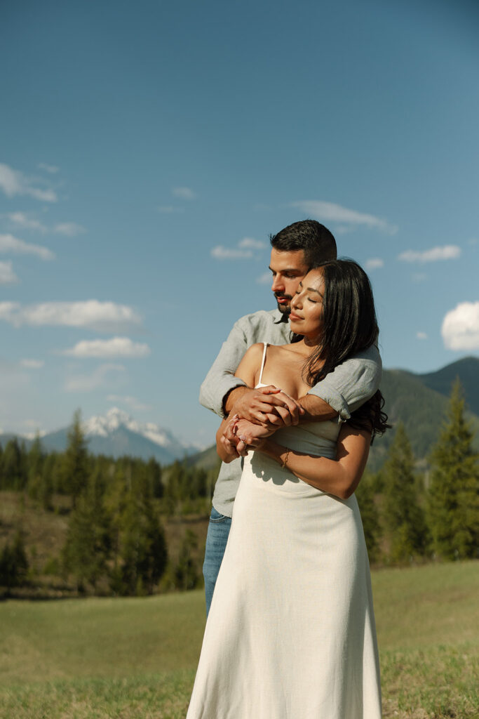 Couple holding hands in a wide open landscape during their Glacier National Park engagement session
