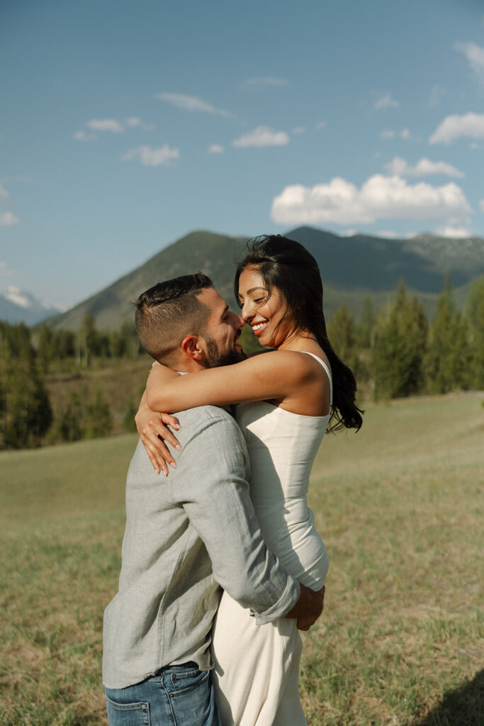 Couple holding hands in a wide open landscape during their Glacier National Park engagement session
