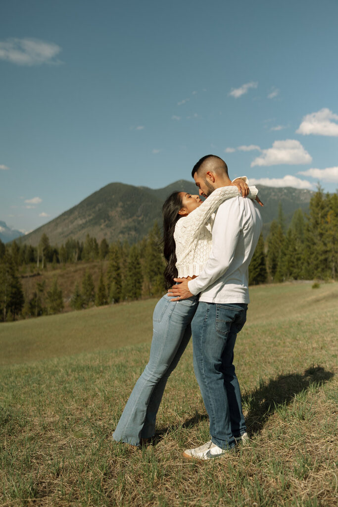 Couple holding hands in a wide open landscape during their Glacier National Park engagement session
