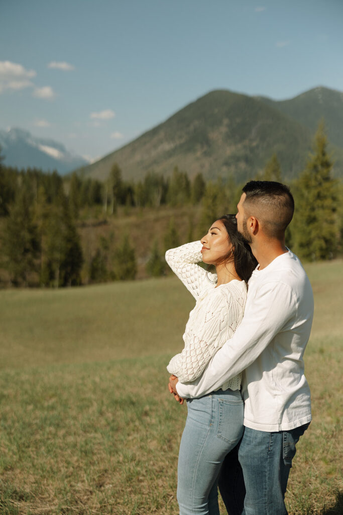 Couple holding hands in a wide open landscape during their Glacier National Park engagement session
