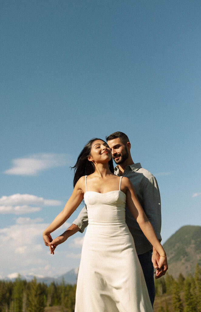 Romantic moment between couple surrounded by scenic views in Glacier National Park engagement session
