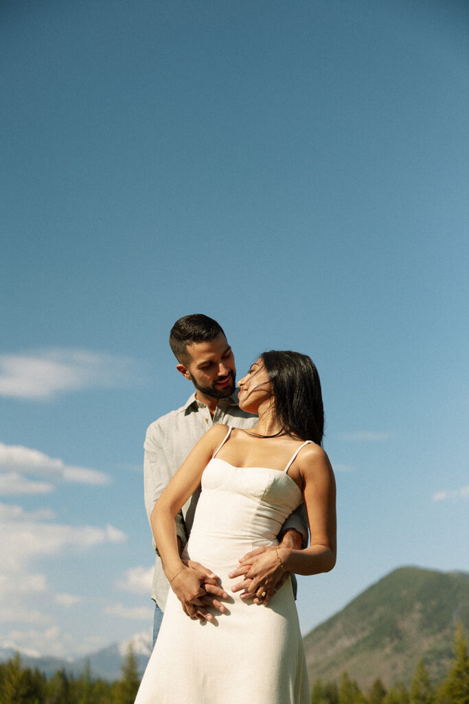 Romantic moment between couple surrounded by scenic views in Glacier National Park engagement session