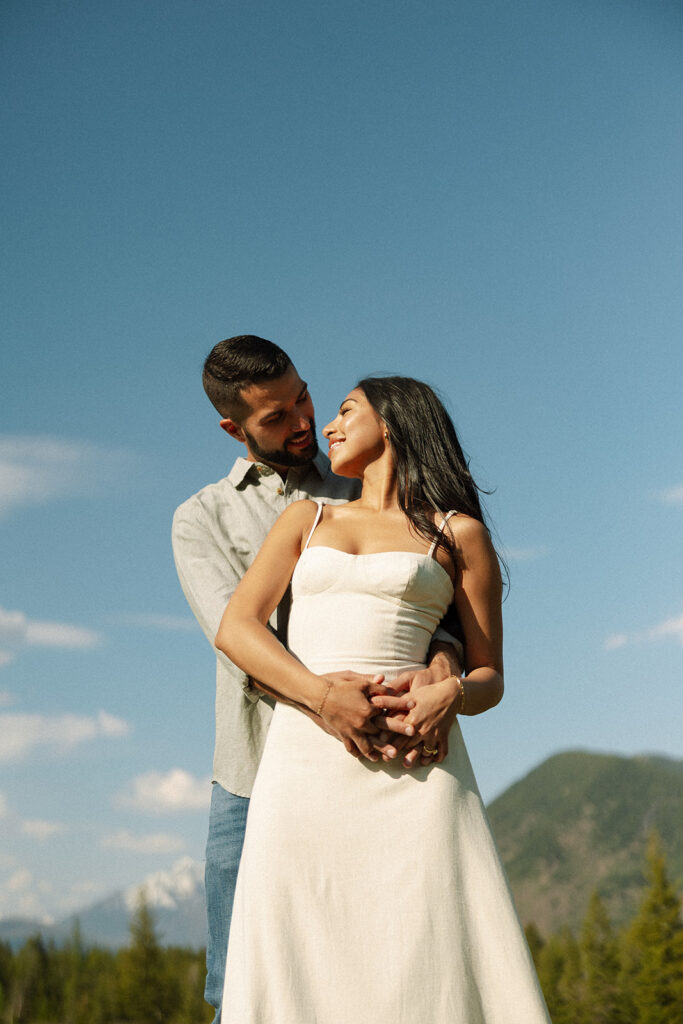 Romantic moment between couple surrounded by scenic views in Glacier National Park engagement session