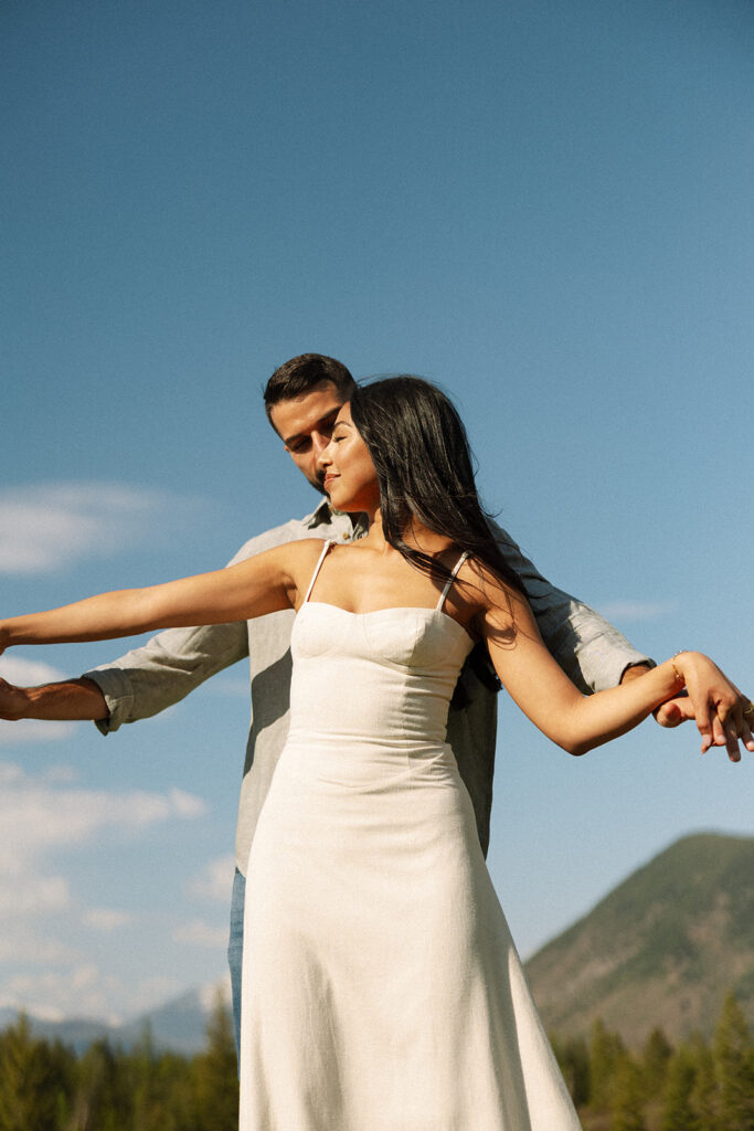 Romantic moment between couple surrounded by scenic views in Glacier National Park engagement session