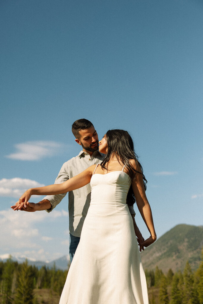 Romantic moment between couple surrounded by scenic views in Glacier National Park engagement session