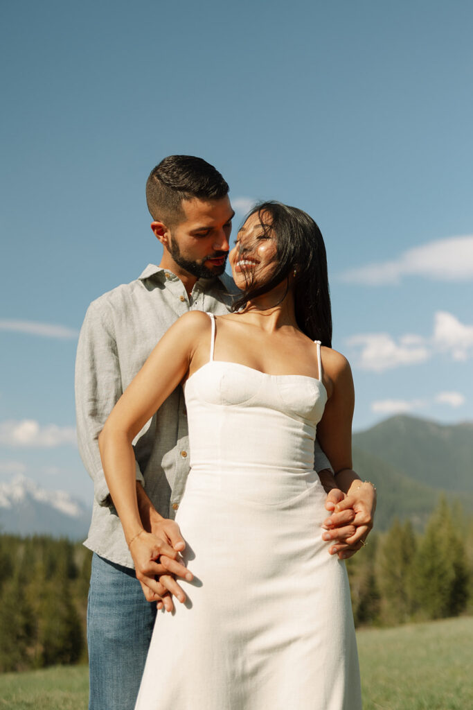 Romantic moment between couple surrounded by scenic views in Glacier National Park engagement session
