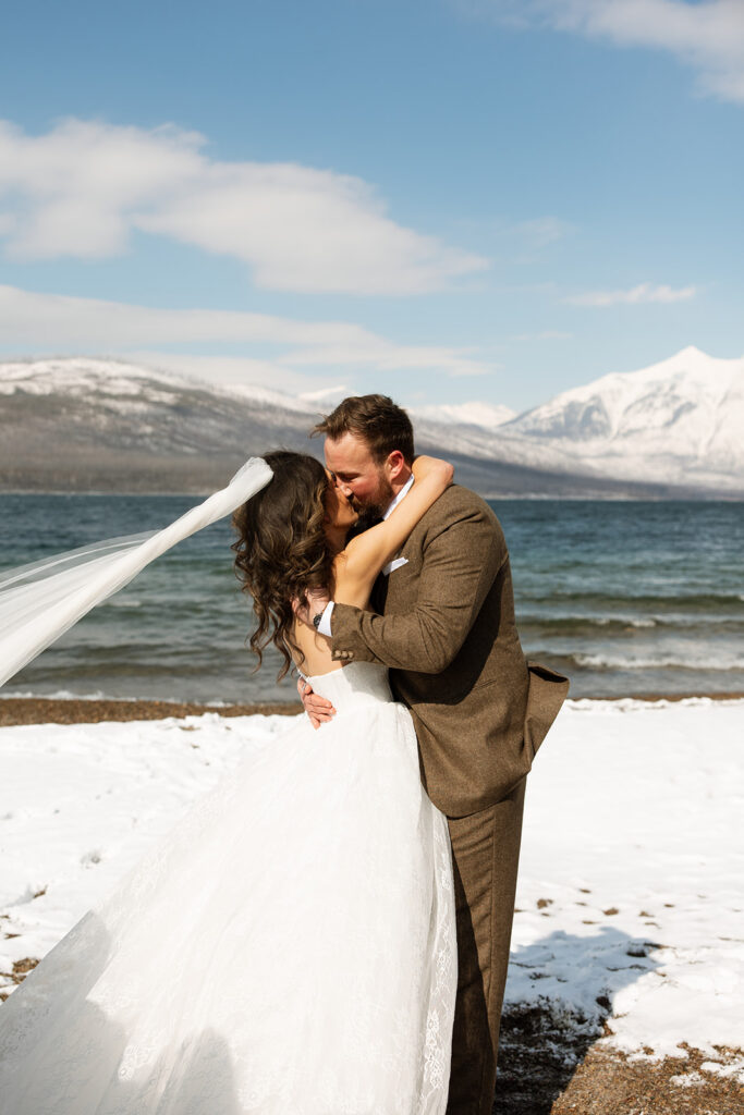 Emotional ceremony during an elopement at Lake McDonald with guests gathered in a quiet snowy landscape
