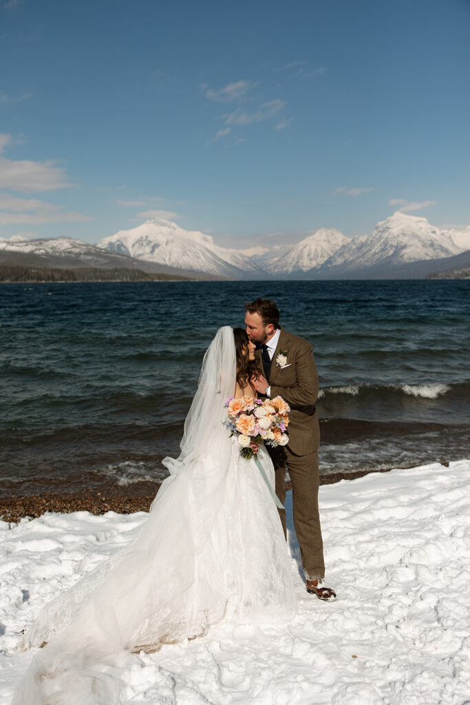 Emotional ceremony during an elopement at Lake McDonald with guests gathered in a quiet snowy landscape