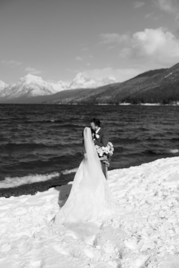 Emotional ceremony during an elopement at Lake McDonald with guests gathered in a quiet snowy landscape