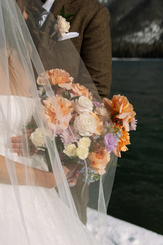 Emotional ceremony during an elopement at Lake McDonald with guests gathered in a quiet snowy landscape