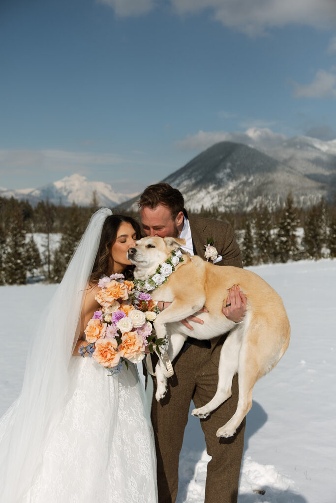 Couple walking along a frozen lake in Glacier National Park during a romantic winter elopement