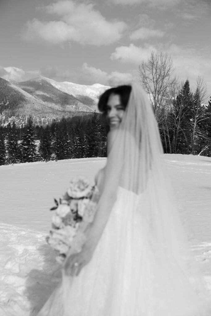 Bride and groom embracing in a snowy mountain setting during a quiet winter wedding day
