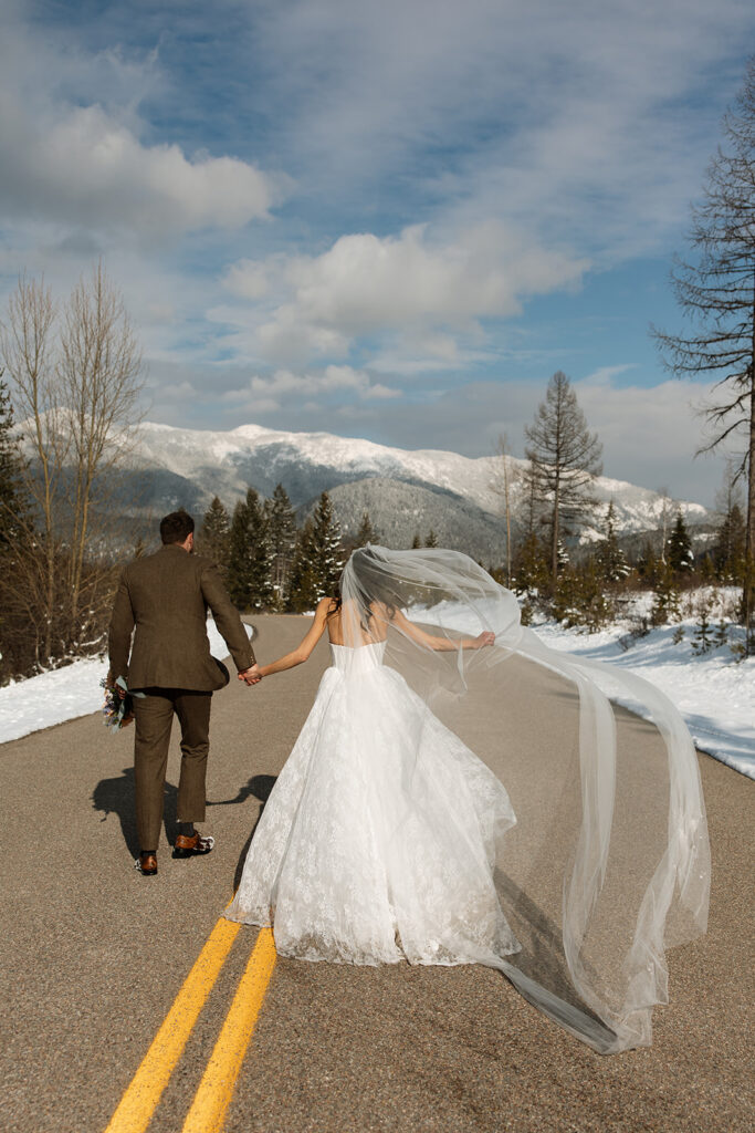 Bride and groom embracing in a snowy mountain setting during a quiet winter wedding day
