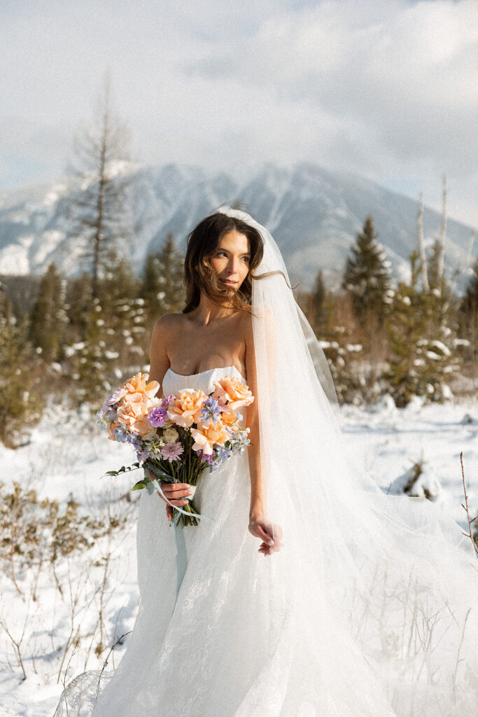Bride and groom embracing in a snowy mountain setting during a quiet winter wedding day
