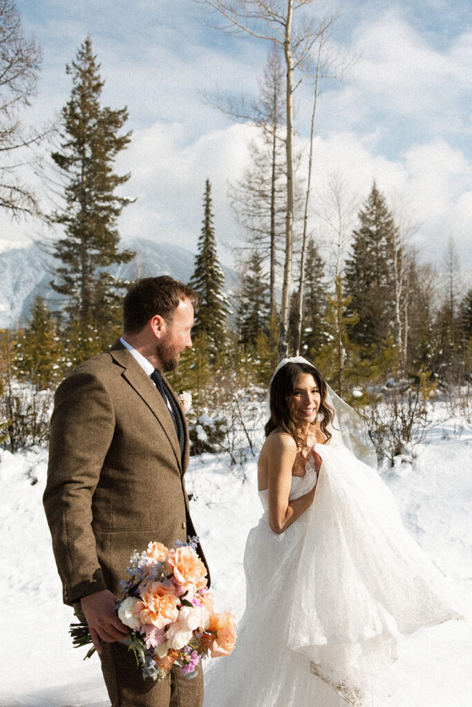 Bride and groom embracing in a snowy mountain setting during a quiet winter wedding day