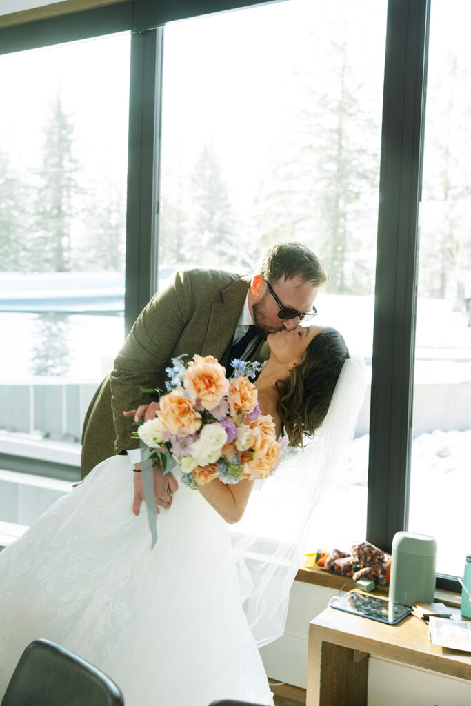 Intimate wedding moment inside a cozy cabin with mountain views and soft natural light
