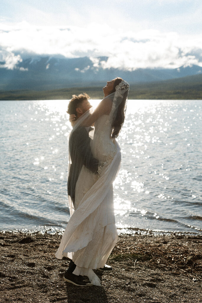 Newly married couple celebrating their Glacier National Park elopement in a beautiful natural landscape.