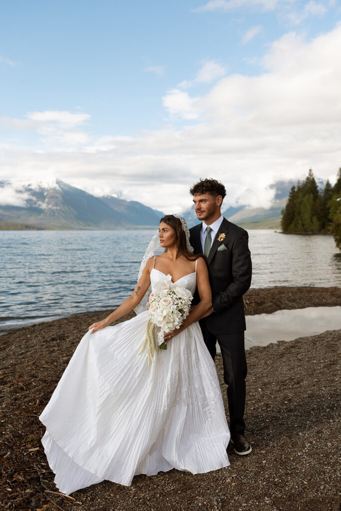 Bride and groom sharing intimate moments along the shoreline of Lake McDonald in Glacier National Park.
