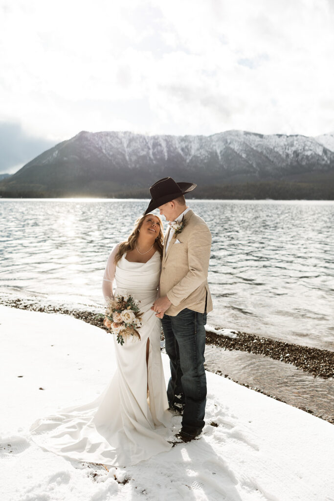 Couple embracing during an intimate Glacier National Park elopement surrounded by mountain scenery
